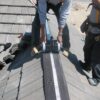worker rolling out ventilation meshing on roof